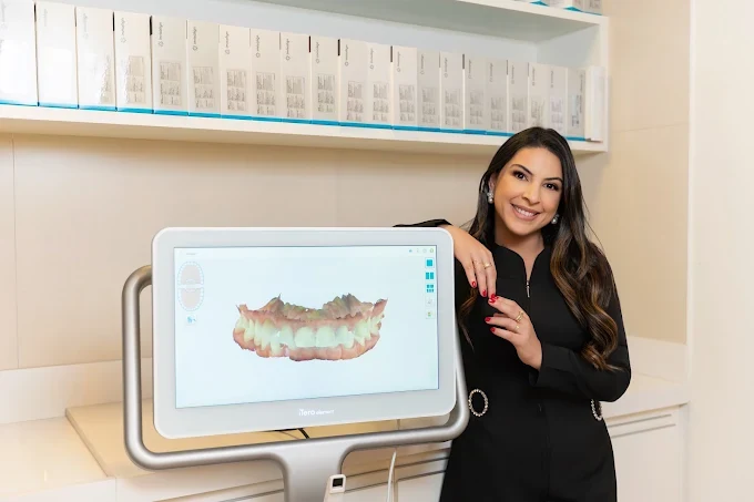 Dra. Rosália Dias Romeiro ao lado do scanner intraoral digital, analisando o escaneamento 3D de um paciente no consultório da Implanto Clínica Odontológica
